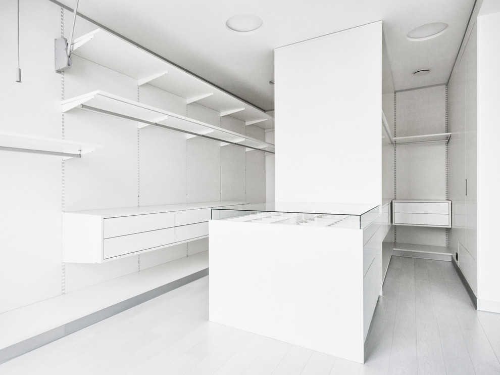Large contemporary gender neutral walk-in wardrobe in Moscow with flat-panel cabinets and white cabinets.