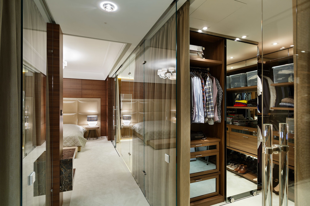 Идея дизайна: гардеробная комната унисекс в современном стиле с стеклянными фасадами, ковровым покрытием и бежевым полом