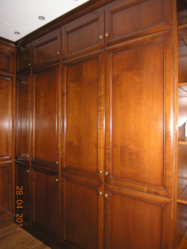 Стильный дизайн: шкаф в нише среднего размера в викторианском стиле с фасадами с утопленной филенкой, коричневыми фасадами и паркетным полом среднего тона - последний тренд