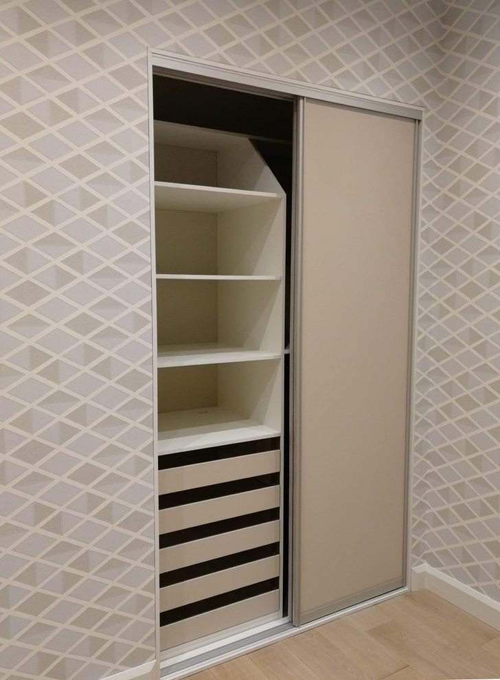 Immagine di un armadio o armadio a muro design di medie dimensioni con ante lisce, ante beige, pavimento in laminato e pavimento beige