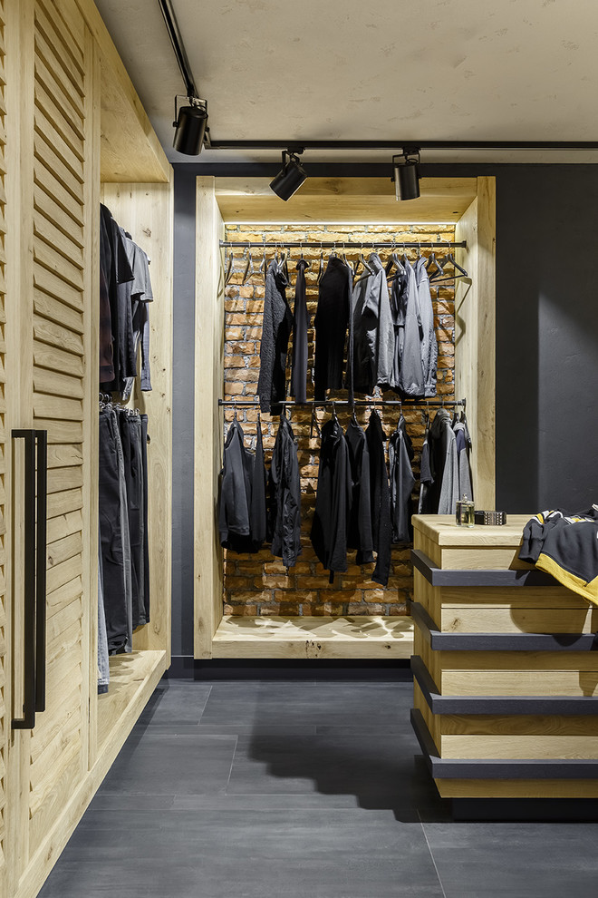 Идея дизайна: гардеробная комната в стиле лофт с открытыми фасадами и серым полом для мужчин