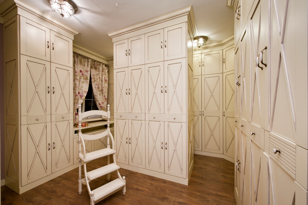 モスクワにある地中海スタイルのおしゃれなフィッティングルーム (白いキャビネット、無垢フローリング、レイズドパネル扉のキャビネット) の写真