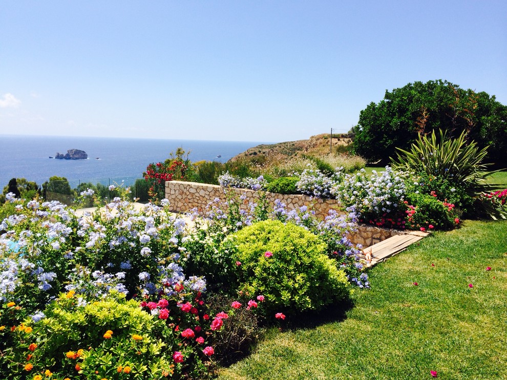 Ispirazione per un giardino mediterraneo esposto in pieno sole con un muro di contenimento