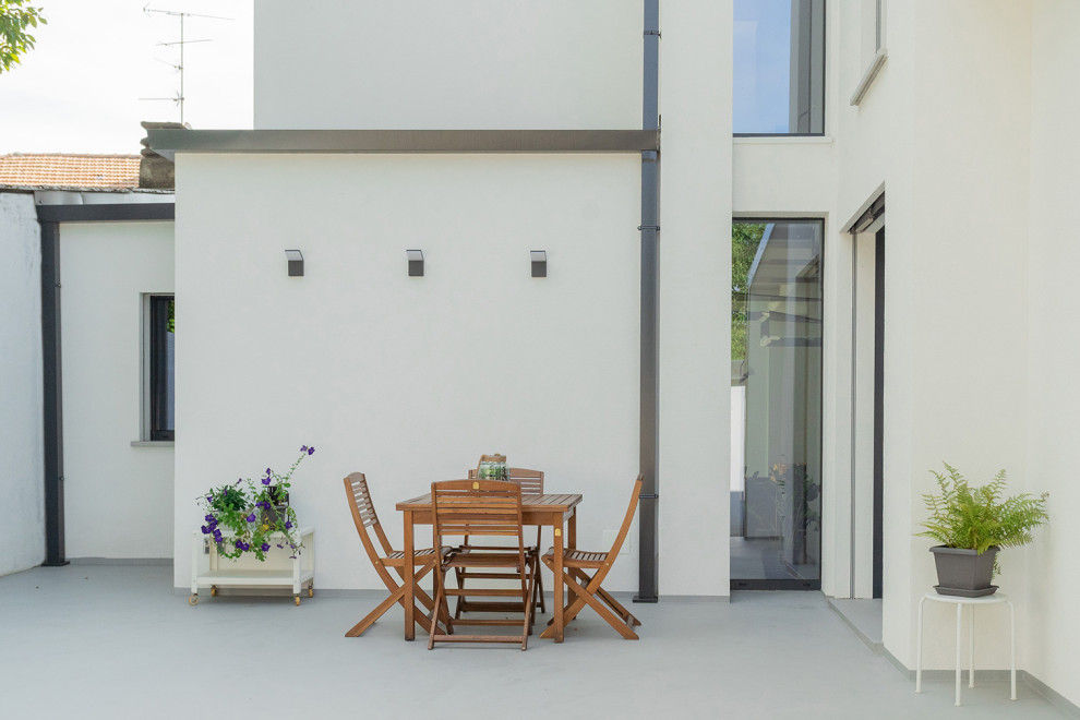Esempio di un giardino minimal esposto a mezz'ombra di medie dimensioni e dietro casa con pavimentazioni in cemento e recinzione in pietra