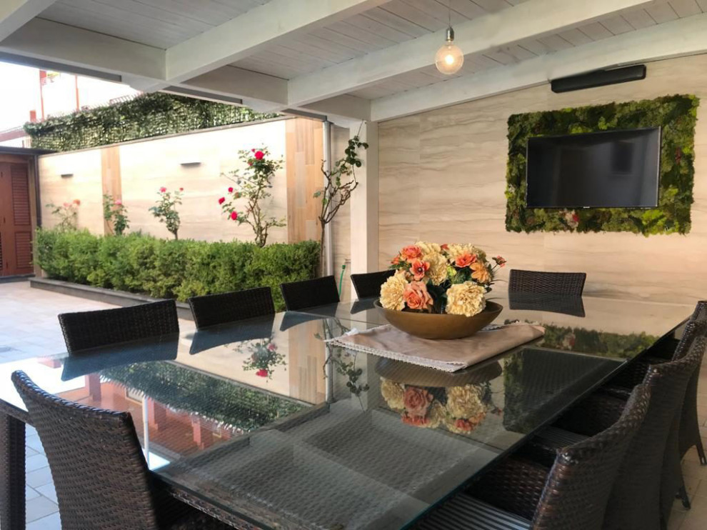 Diseño de patio minimalista grande en patio delantero con jardín vertical y adoquines de ladrillo