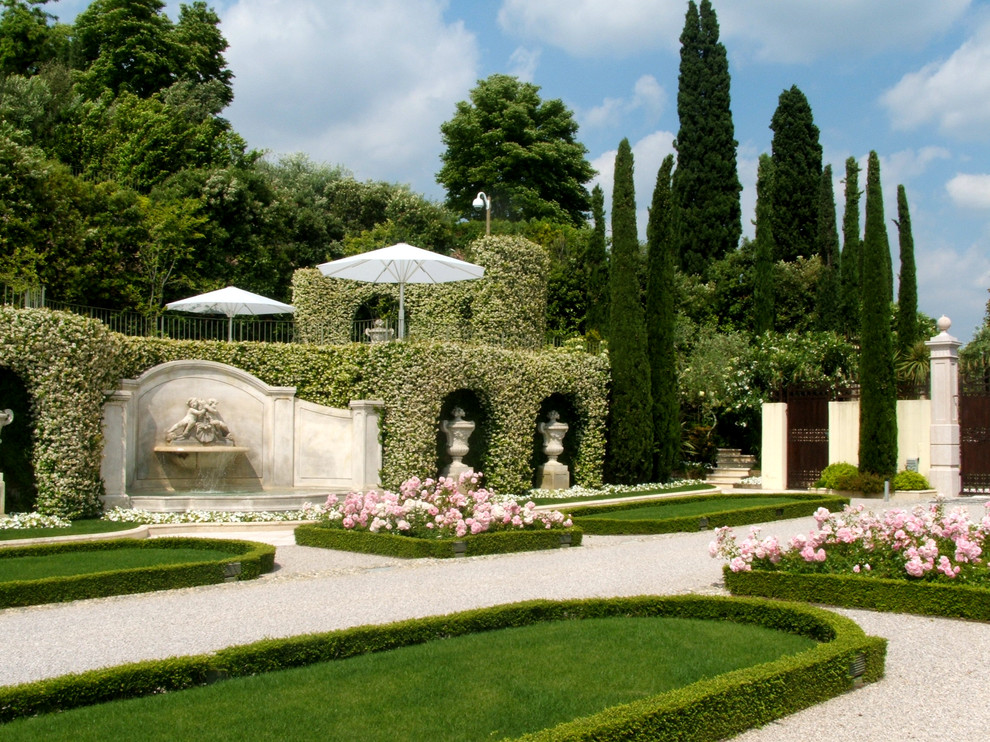 Classic formal full sun garden for summer in Milan with a water feature and gravel.