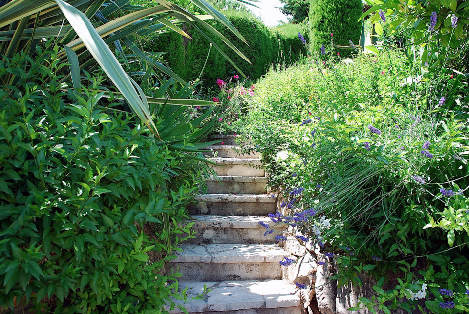 Ispirazione per un giardino mediterraneo esposto a mezz'ombra di medie dimensioni in estate con pavimentazioni in pietra naturale e scale