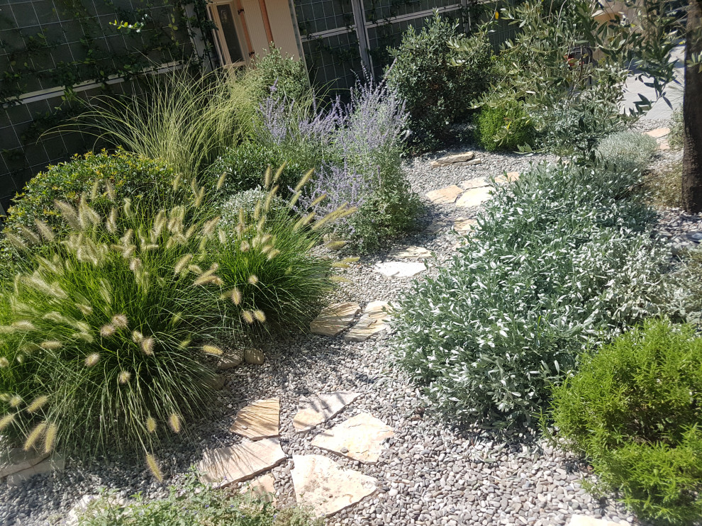 Photo of a small mediterranean back xeriscape and private full sun garden for summer in Other with gravel.
