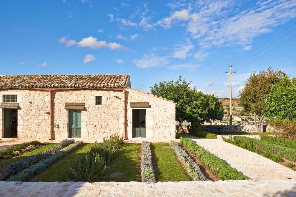 Esempio di un orto in giardino mediterraneo esposto a mezz'ombra di medie dimensioni e nel cortile laterale in estate con pavimentazioni in mattoni