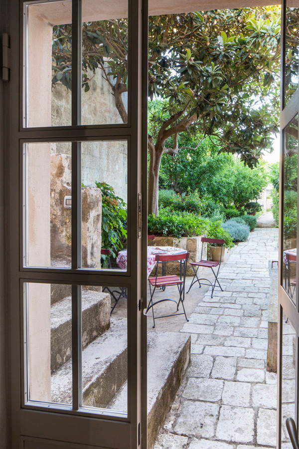 Esempio di un ampio giardino formale mediterraneo esposto in pieno sole dietro casa in estate con pavimentazioni in pietra naturale