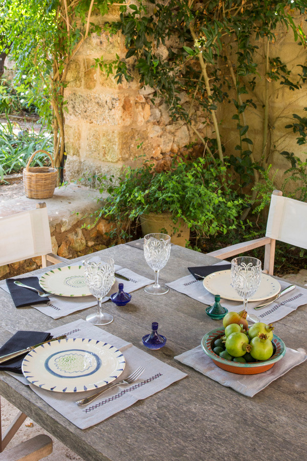 Foto di un ampio giardino formale mediterraneo esposto in pieno sole dietro casa in estate con pavimentazioni in pietra naturale
