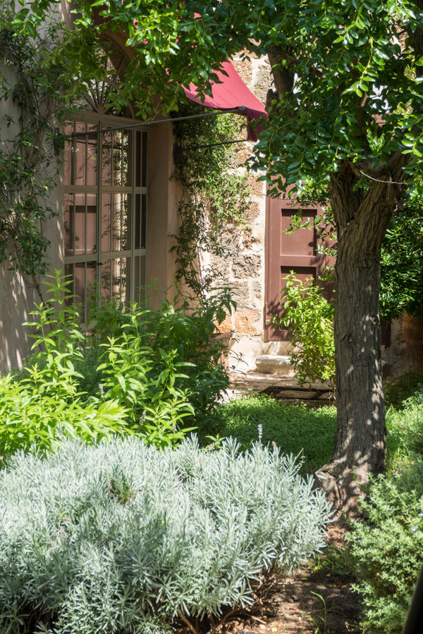 Geometrischer, Geräumiger Mediterraner Garten im Sommer, hinter dem Haus mit direkter Sonneneinstrahlung und Natursteinplatten in Sonstige