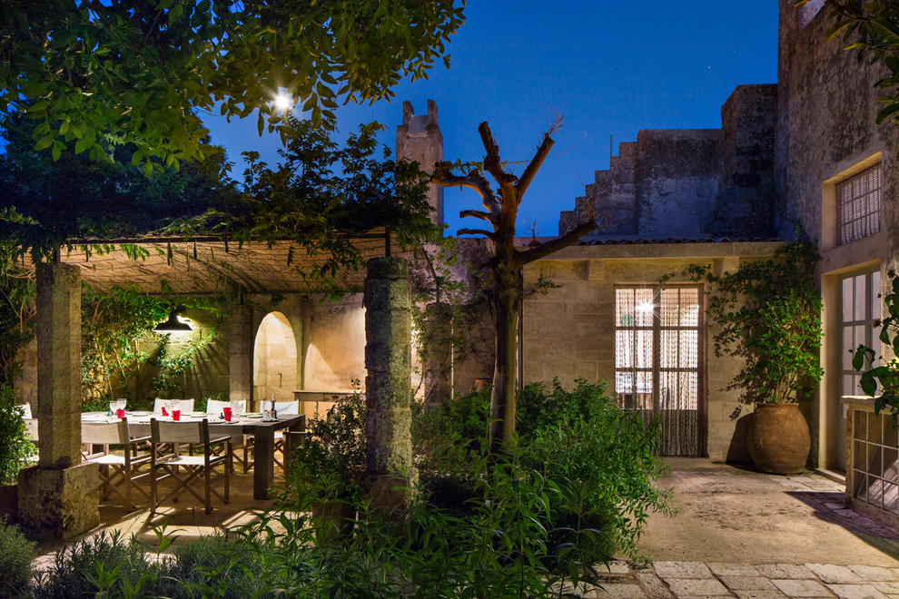 Immagine di un ampio giardino formale mediterraneo esposto in pieno sole dietro casa in estate con pavimentazioni in pietra naturale