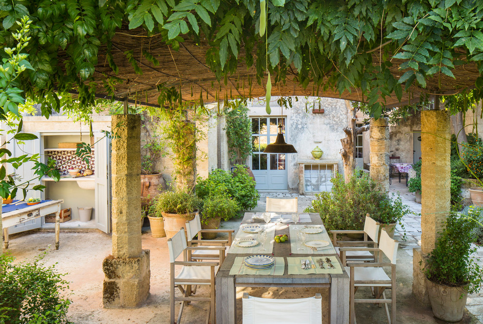 Esempio di un ampio patio o portico mediterraneo dietro casa con pavimentazioni in pietra naturale