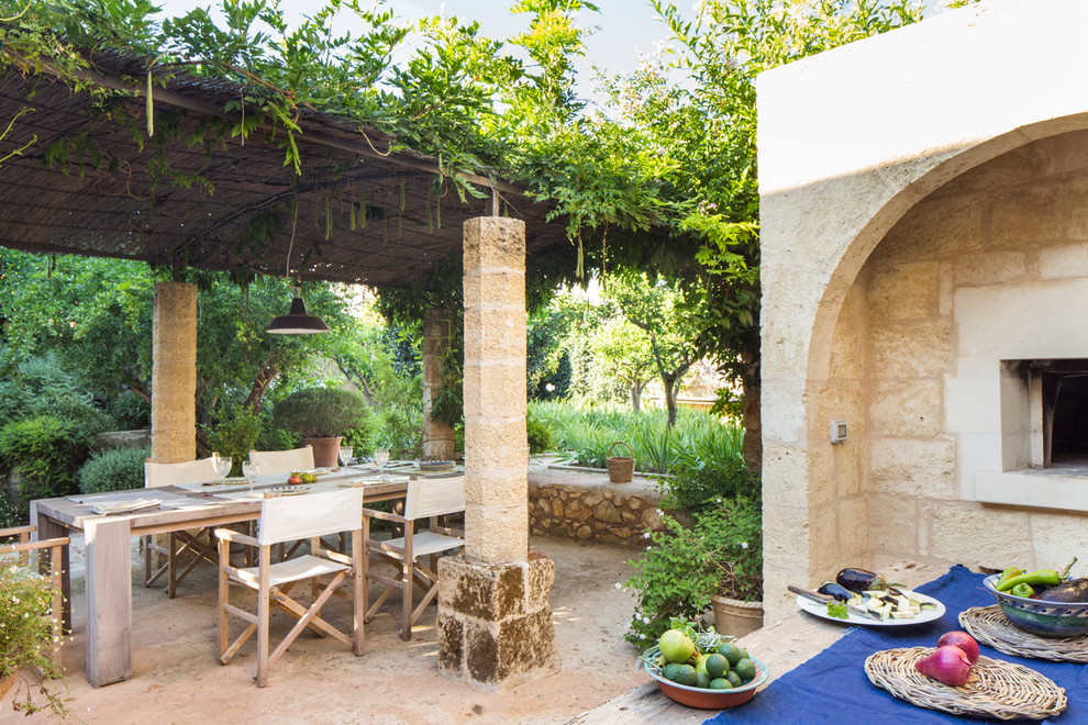 Immagine di un ampio patio o portico mediterraneo dietro casa con pavimentazioni in pietra naturale