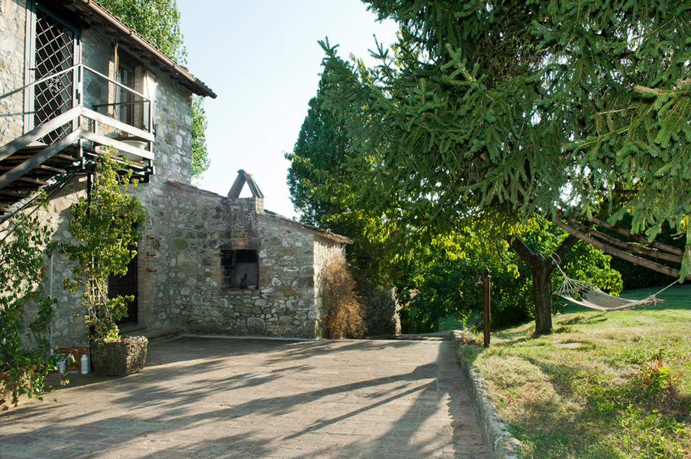 Foto di un ampio giardino country esposto in pieno sole davanti casa in estate con pavimentazioni in pietra naturale