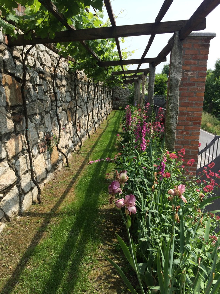 Ispirazione per un giardino xeriscape country esposto in pieno sole di medie dimensioni in primavera con un muro di contenimento e un pendio, una collina o una riva