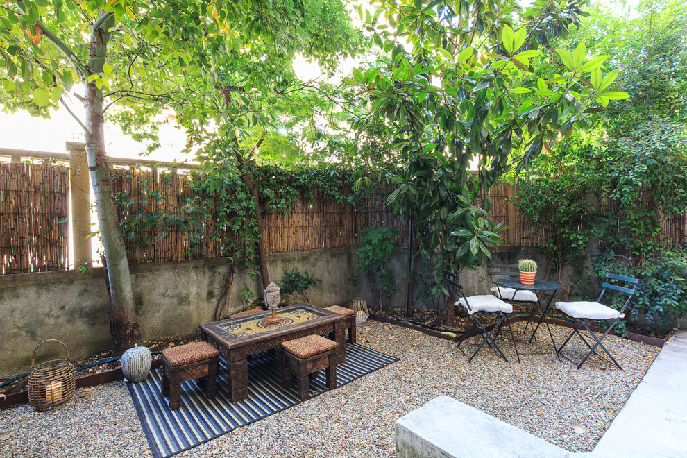 Imagen de jardín de secano de estilo zen de tamaño medio en patio trasero con muro de contención, exposición parcial al sol y gravilla