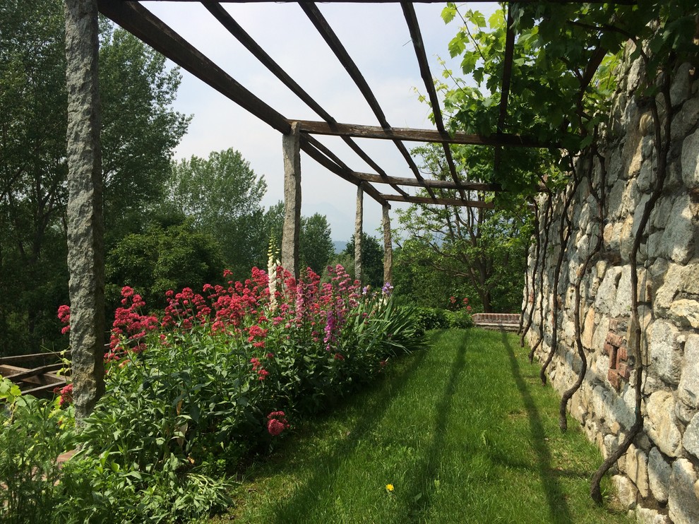 Esempio di un giardino xeriscape country esposto in pieno sole di medie dimensioni in primavera con un muro di contenimento e un pendio, una collina o una riva