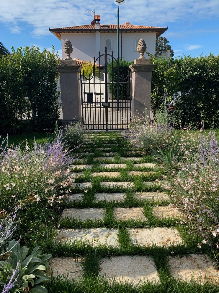 Aménagement d'un grand jardin avant romantique au printemps avec un point d'eau, une exposition ensoleillée et des pavés en pierre naturelle.
