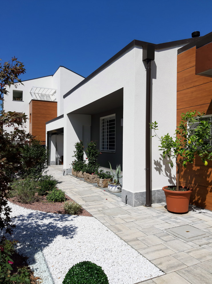Foto di un grande vialetto d'ingresso minimal esposto in pieno sole dietro casa con pavimentazioni in pietra naturale e recinzione in metallo