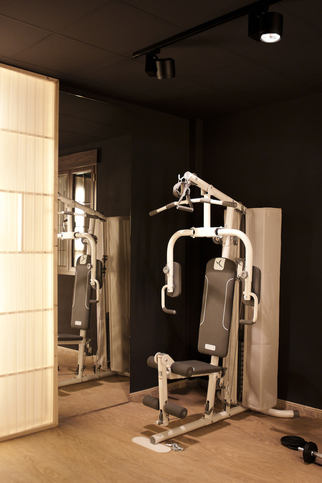 Kleiner, Multifunktionaler Moderner Fitnessraum mit schwarzer Wandfarbe und braunem Holzboden in Sonstige