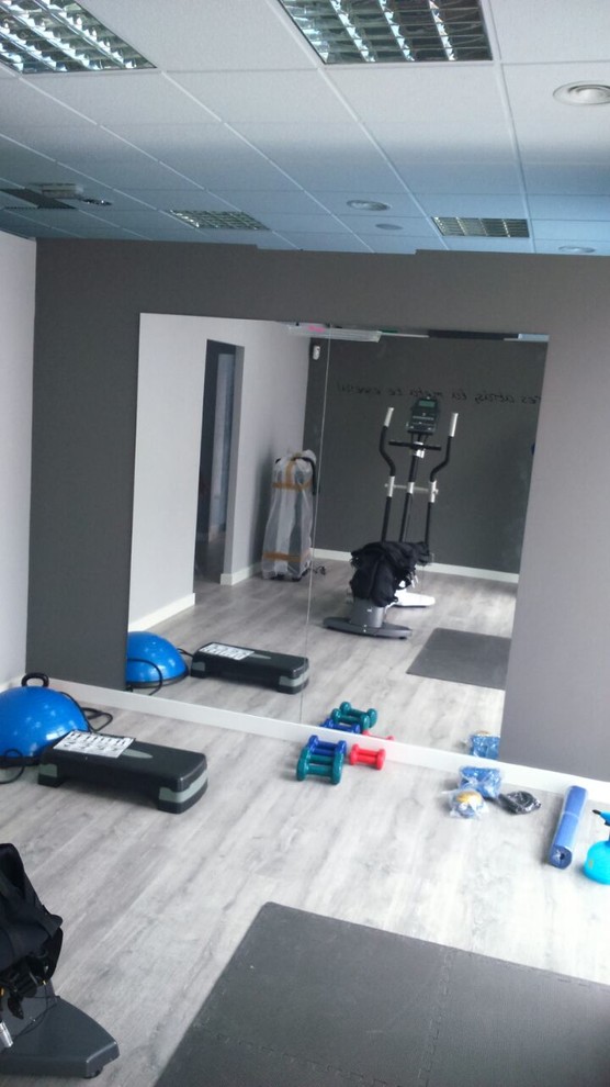 Multifunktionaler, Kleiner Klassischer Fitnessraum mit grauer Wandfarbe und gebeiztem Holzboden in Madrid