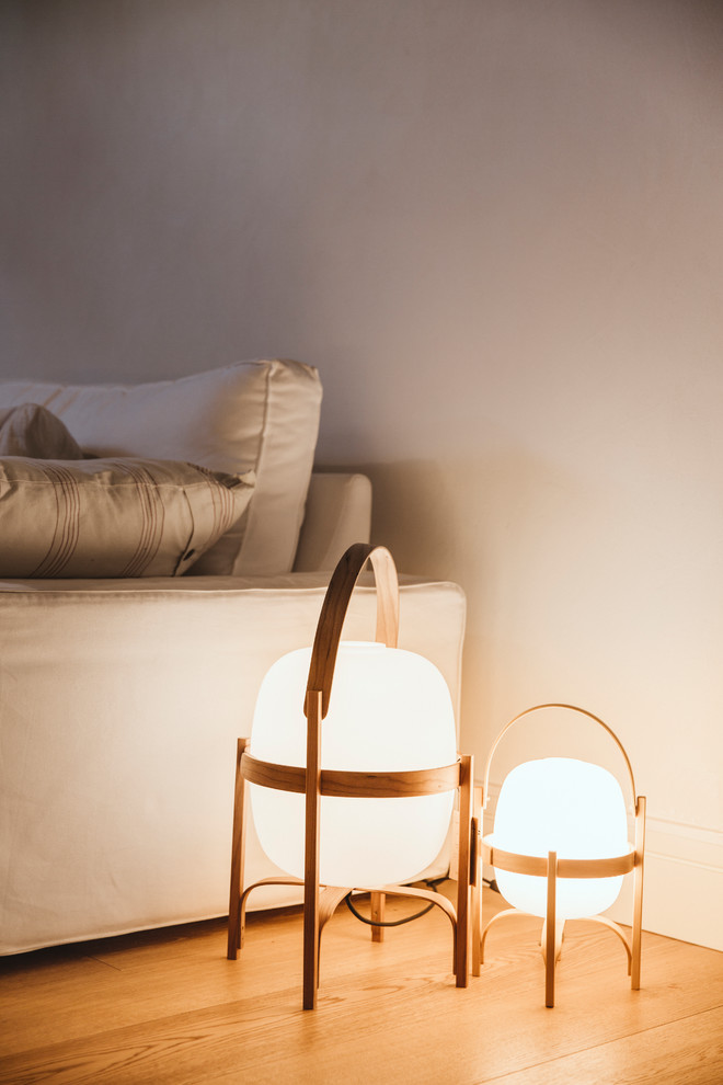 This is an example of a mediterranean living room in Barcelona with light hardwood flooring.