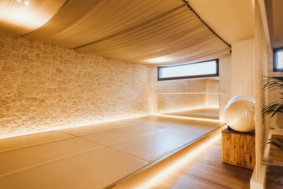 Ispirazione per uno studio yoga mediterraneo con parquet chiaro