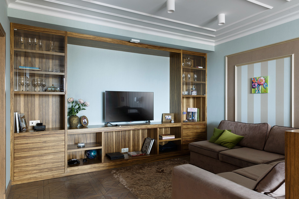 На фото: парадная гостиная комната в современном стиле с паркетным полом среднего тона, отдельно стоящим телевизором, разноцветными стенами и коричневым диваном