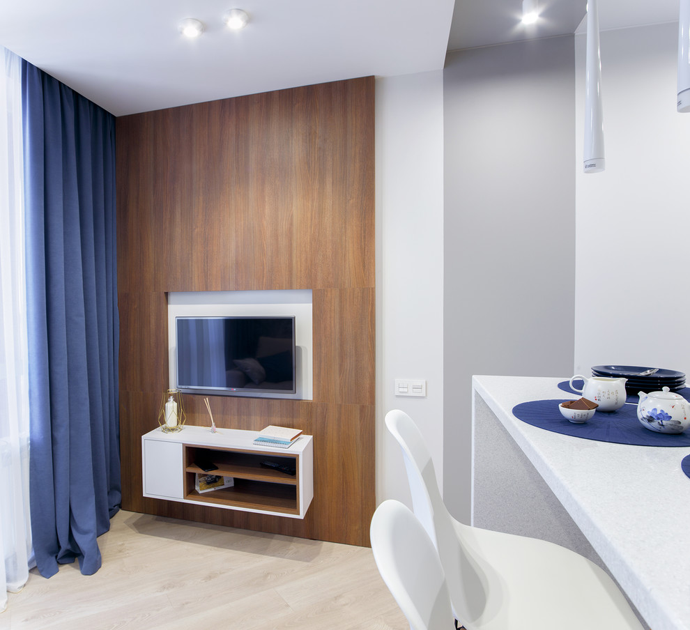 Cette photo montre un petit salon tendance ouvert avec un mur blanc, sol en stratifié, un téléviseur fixé au mur et un sol beige.