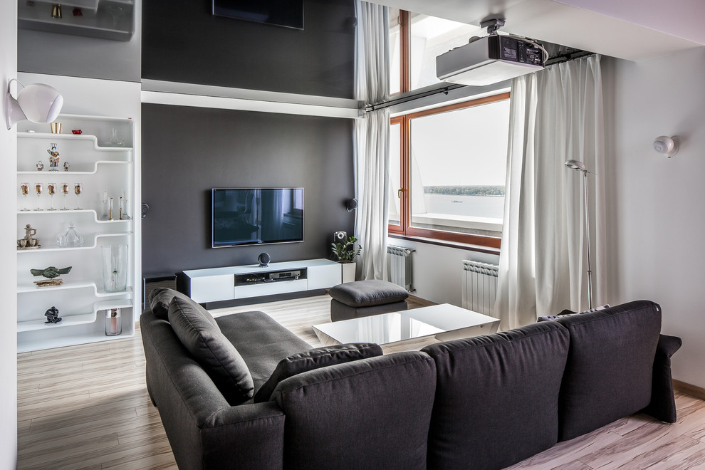 Стильный дизайн: парадная, открытая гостиная комната в современном стиле с разноцветными стенами, светлым паркетным полом и телевизором на стене - последний тренд