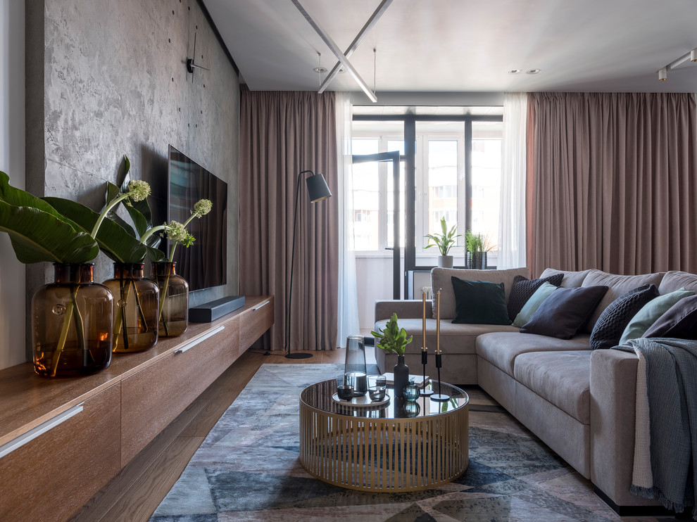 Стильный дизайн: парадная гостиная комната:: освещение в современном стиле с серыми стенами, паркетным полом среднего тона, телевизором на стене и коричневым полом - последний тренд