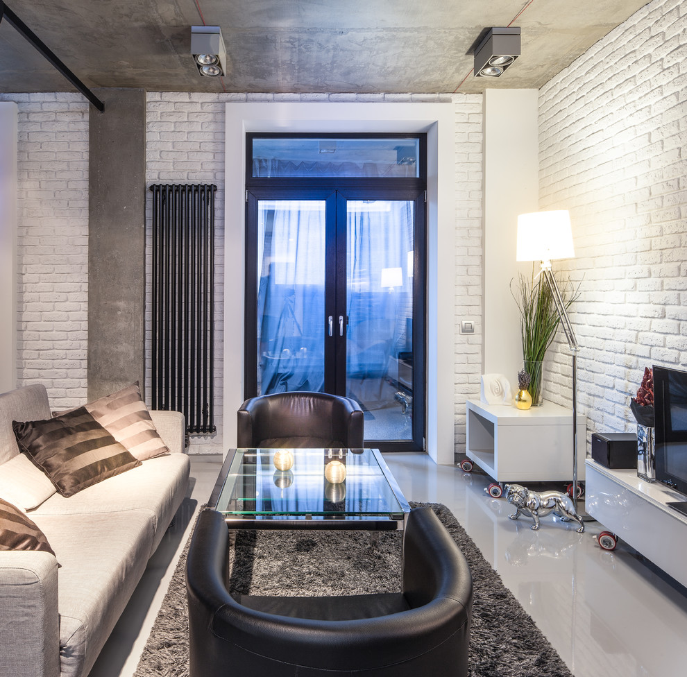 Modelo de salón abierto actual pequeño con paredes blancas, suelo de cemento, televisor independiente y suelo gris