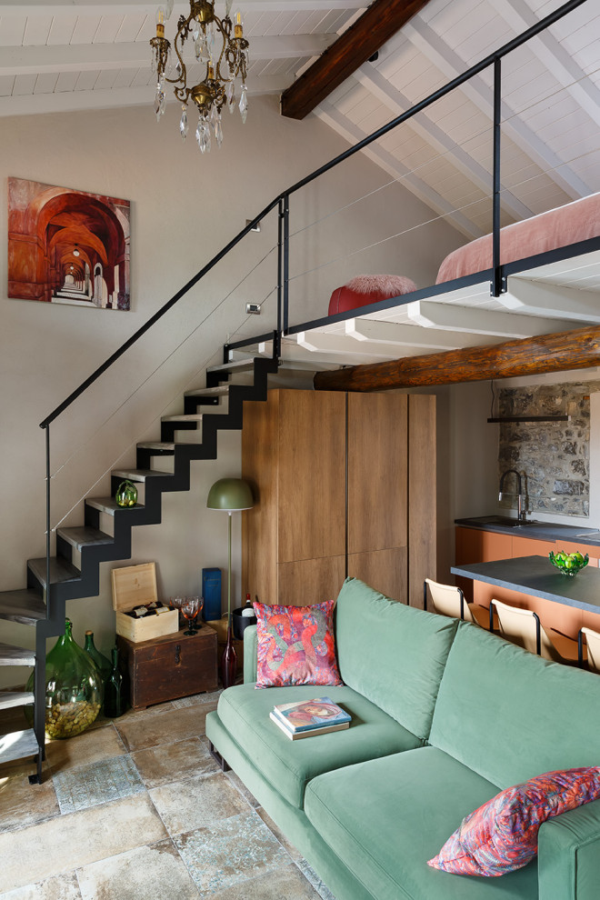 Ispirazione per un piccolo soggiorno mediterraneo stile loft con pavimento in gres porcellanato, camino classico e TV a parete