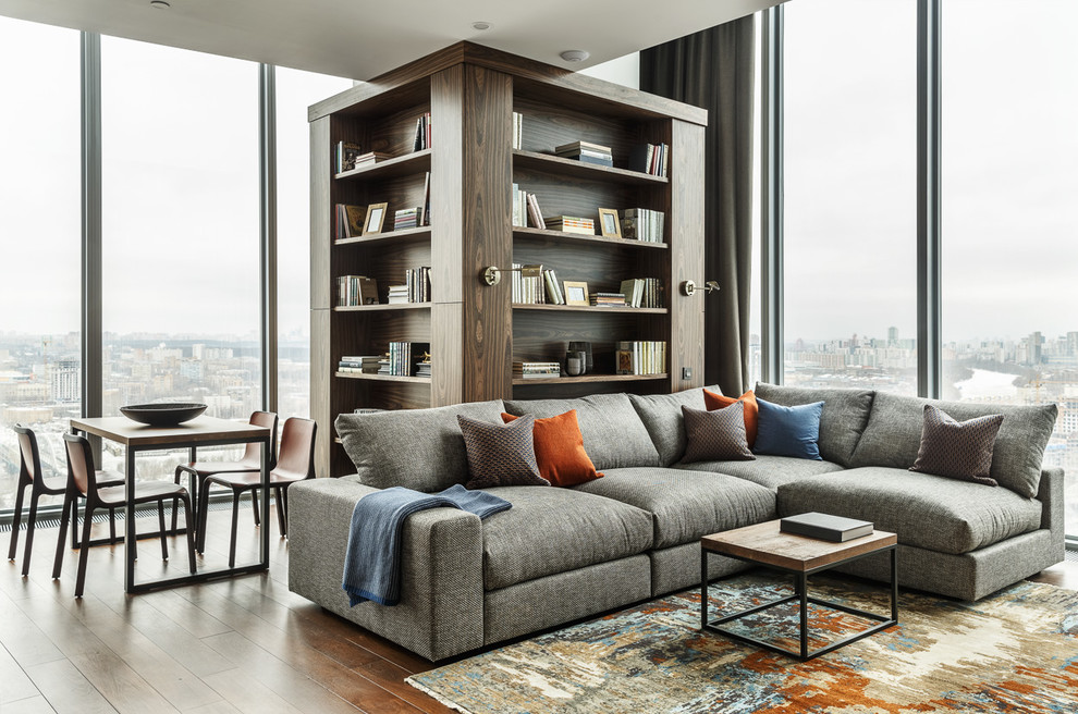 This is an example of a medium sized contemporary open plan living room in Moscow with a reading nook, grey walls, medium hardwood flooring, no fireplace, no tv and brown floors.