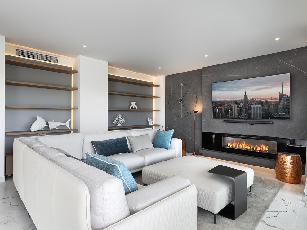 Imagen de sala de estar abierta contemporánea de tamaño medio con chimenea lineal, marco de chimenea de metal, televisor colgado en la pared, suelo blanco y paredes grises