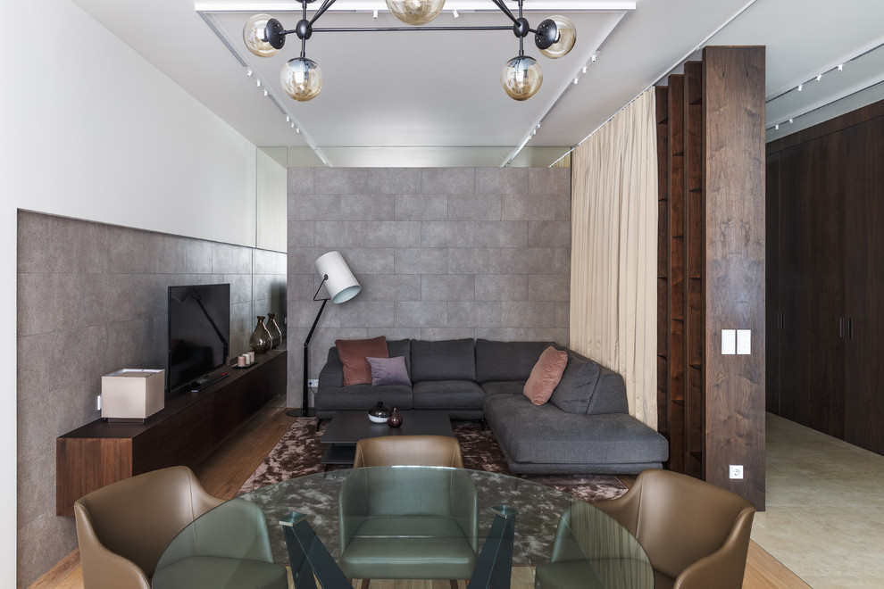На фото: парадная, открытая гостиная комната в современном стиле с серыми стенами и отдельно стоящим телевизором с