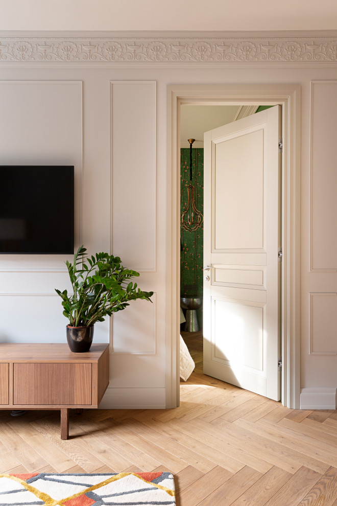 Стильный дизайн: маленькая открытая гостиная комната в стиле неоклассика (современная классика) с серыми стенами, паркетным полом среднего тона, телевизором на стене и коричневым полом для на участке и в саду - последний тренд