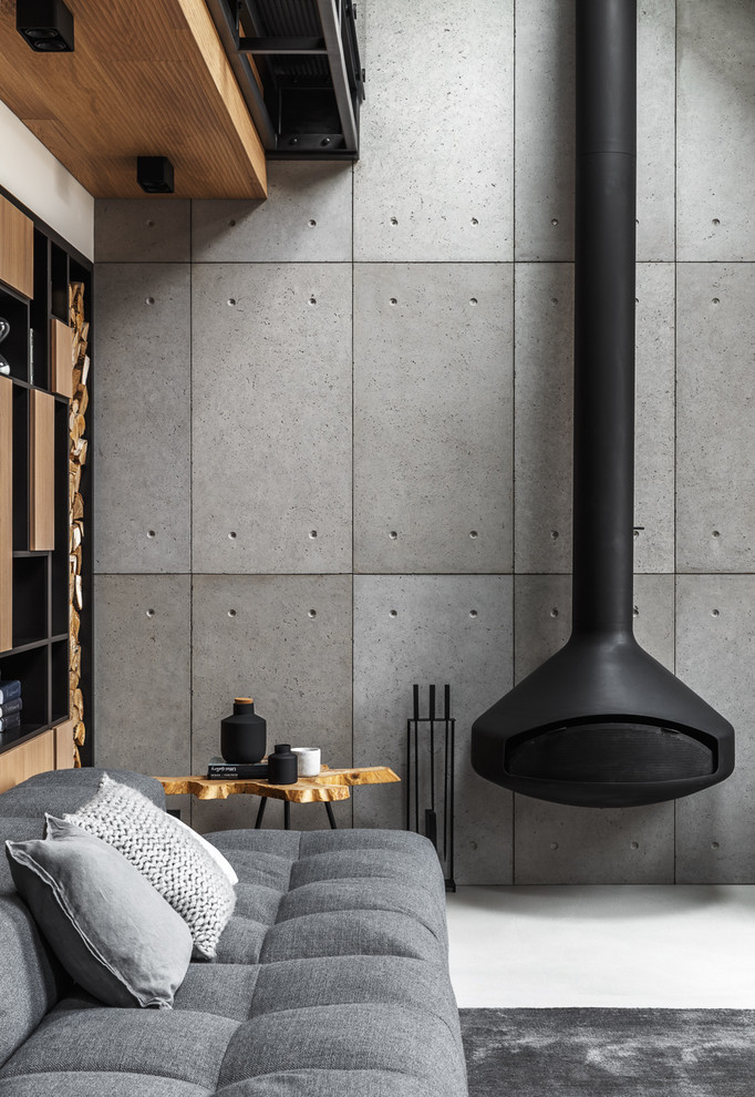 Exempel på ett mellanstort modernt allrum med öppen planlösning, med betonggolv, en hängande öppen spis, en spiselkrans i metall, grått golv och grå väggar