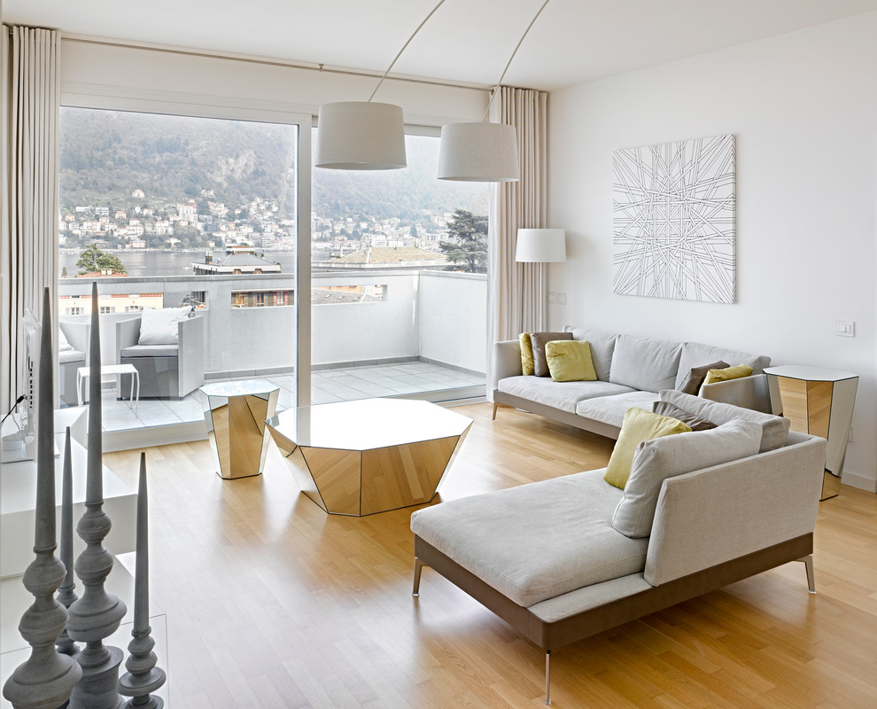 Foto de salón para visitas abierto moderno grande con paredes blancas y suelo de madera clara