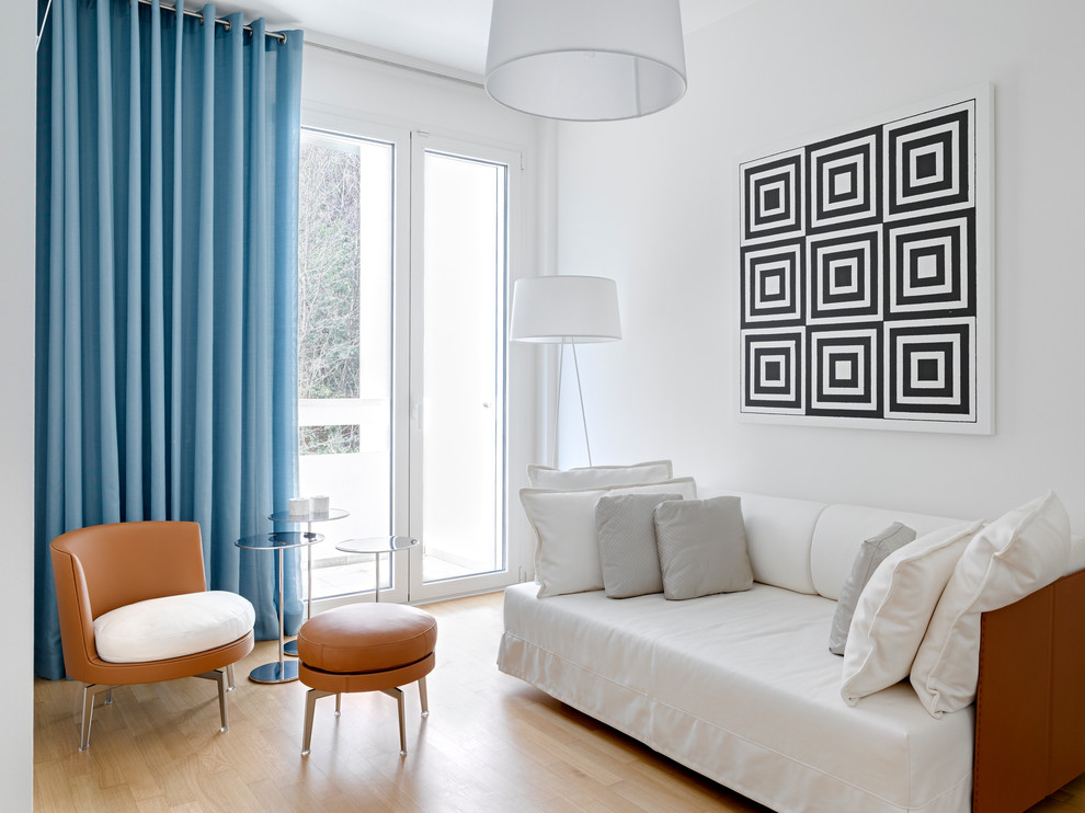 Idée de décoration pour une salle de séjour design de taille moyenne et fermée avec un mur blanc et parquet clair.