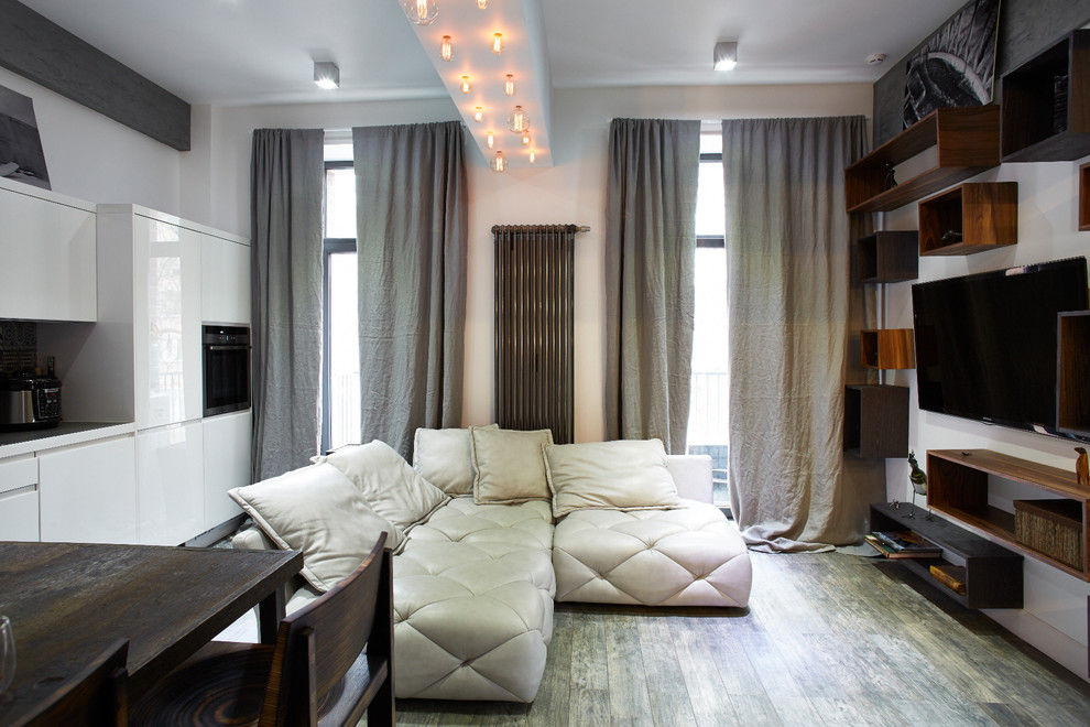 Источник вдохновения для домашнего уюта: парадная, открытая, объединенная гостиная комната в современном стиле с белыми стенами и телевизором на стене