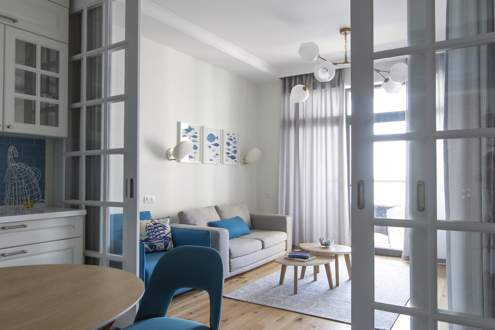Kleines, Abgetrenntes Maritimes Wohnzimmer mit weißer Wandfarbe, braunem Holzboden, freistehendem TV und beigem Boden in Sonstige