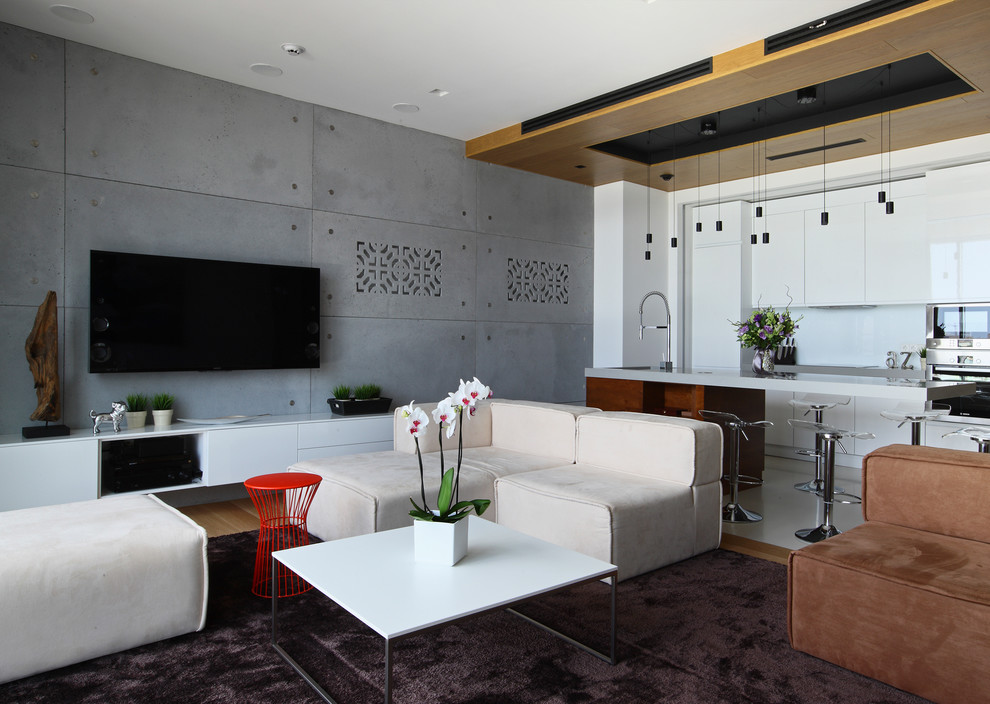 Imagen de salón abierto actual de tamaño medio con televisor colgado en la pared y paredes grises