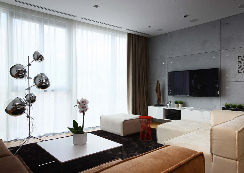 На фото: открытая гостиная комната среднего размера в современном стиле с серыми стенами и телевизором на стене с