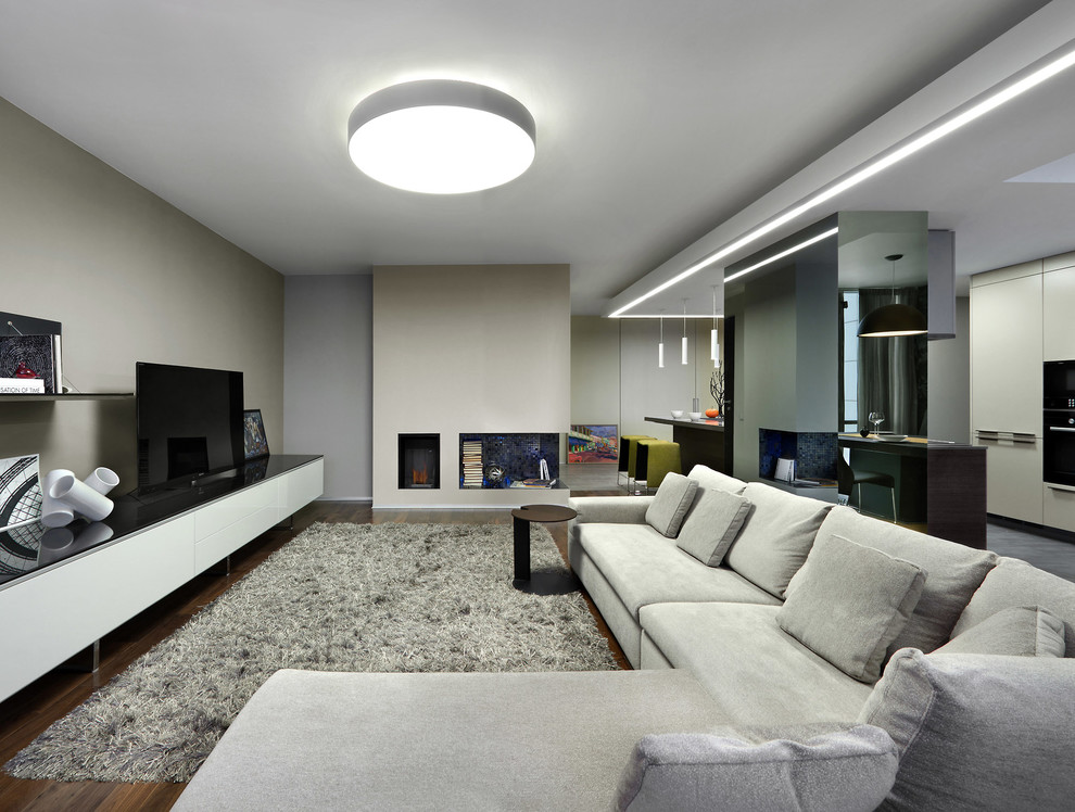 На фото: парадная, открытая гостиная комната в современном стиле с серыми стенами, темным паркетным полом и отдельно стоящим телевизором