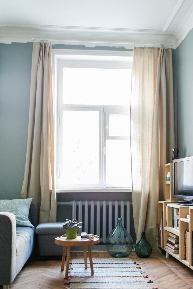 Exemple d'un salon scandinave de taille moyenne avec un mur gris, un sol en bois brun et un téléviseur indépendant.