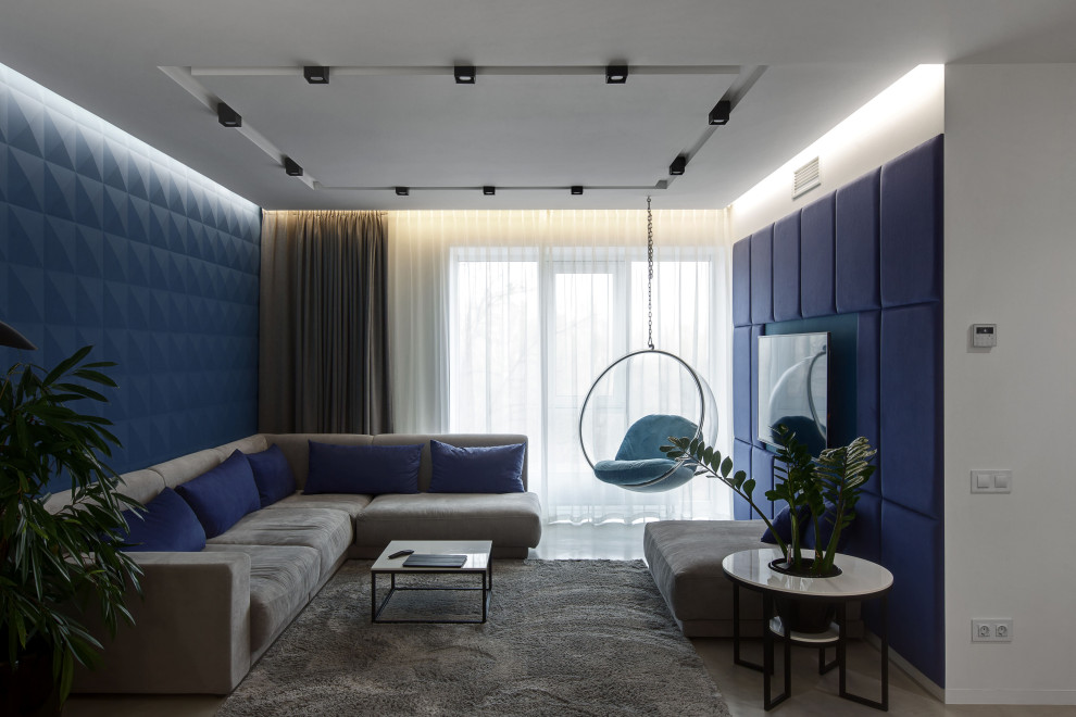 Источник вдохновения для домашнего уюта: изолированная гостиная комната среднего размера в современном стиле с синими стенами, телевизором на стене и серым полом