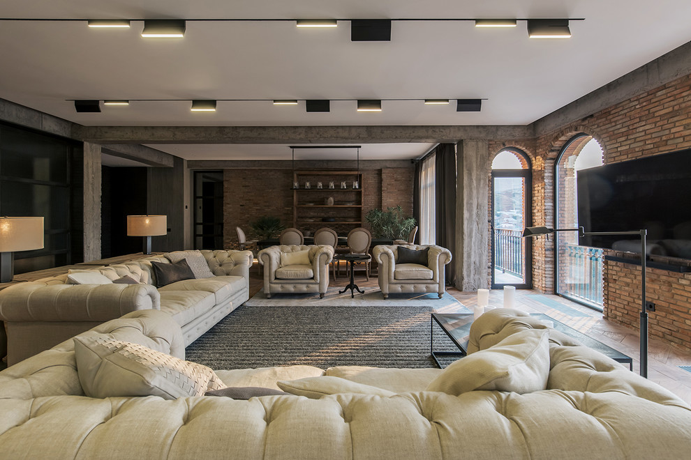 Esempio di un soggiorno industriale aperto con pareti marroni, pavimento in legno massello medio, TV a parete e pavimento beige